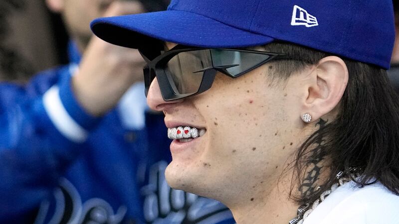 ARCHIVO - El cantante mexicano Peso Pluma sonríe al hablar con el primer pitcher Julio Urias...