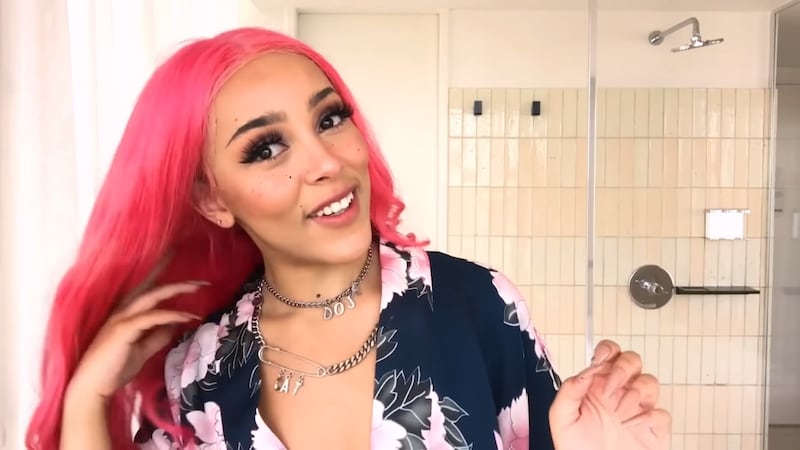 Doja Cat demostrando una rutina de maquillaje para Vogue Taiwán.