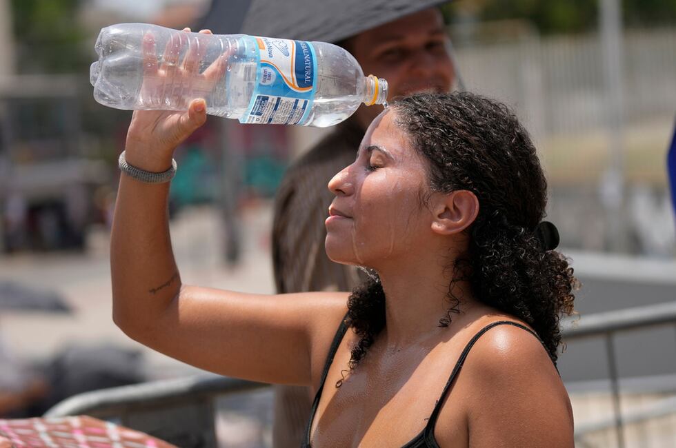 Una seguidora de Taylor Swift se vierte agua para refrescarse en medio de una ola de calor...